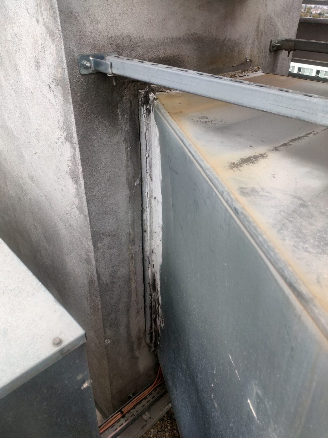 Pénétration d'un conduit dans une souche maçonnée : mastic fissuré, fuite sur toute la hauteur